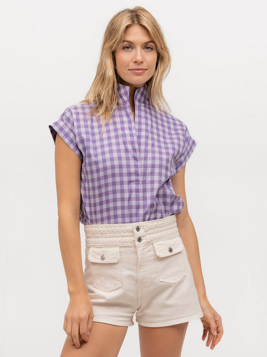 Beautiful woman wearing a short sleeve designer top in purple plaid