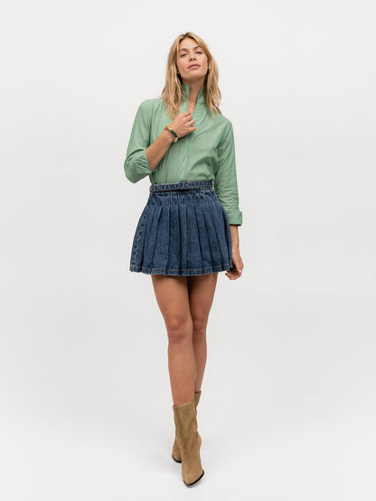 Woman wearing a long-sleeve designer blouse in a soft green cotton fabric